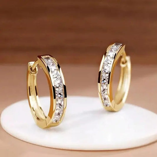 Schicke goldene und kristallene Creolen